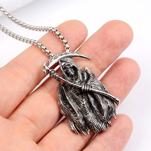 Detailed close-up of a stainless steel Grim Reaper scythe pendant held in hand