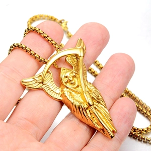 Détail du pendentif Faucheuse dorée avec ailes et faux sur une chaîne à billes chic