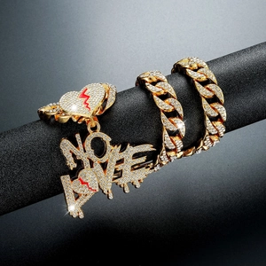 Macro-opname van NO LOVE hanger met rood hart aan gouden hiphop cubaanse ketting