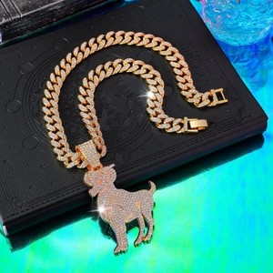 Macro detail of iced-out gold Cuban chain with goat pendant on dark leather book
