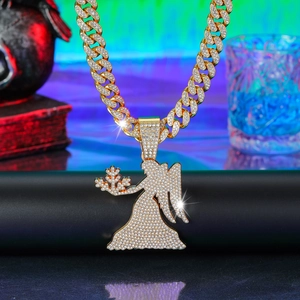 Detailed macro view of gold plated iced out cuban link chain with iced angel pendant