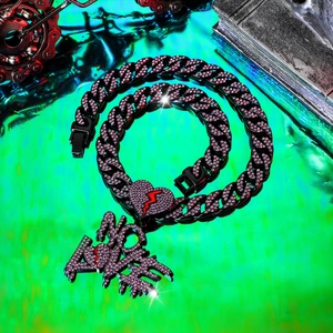 Macro-opname van Cubaanse ketting met roze NO LOVE hanger en gebroken hart detail