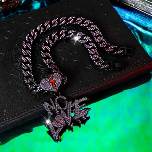 Detail van hiphop-ketting met NO LOVE-letters en hartvormige hanger met paarse strass