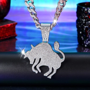 Macro shot of iced out silver bull pendant with white crystals on a thick cuban link chain