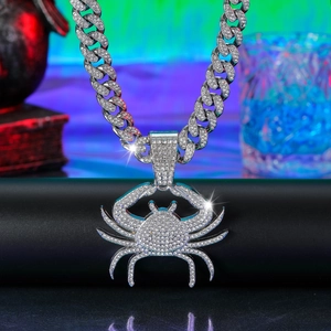 Macro shot of iced out silver crab pendant with rhinestones on a Cuban link chain