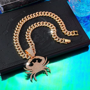 Macro detail of gold-plated iced out Cuban link chain with a diamond crab pendant