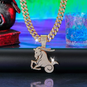Macro detail of iced-out gold Capricorn zodiac pendant on a shiny Cuban link chain