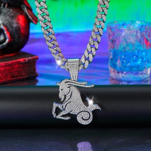 Macro shot of silver Capricorn pendant with iced-out Cuban link chain and rhinestones