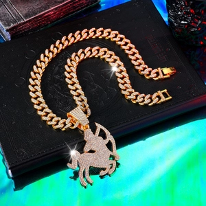 Macro shot of gold Sagittarius pendant with cubic zirconia on iced out Cuban link chain