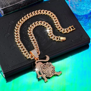 Detailed macro view of an iced-out tiger pendant on a gold Cuban chain necklace