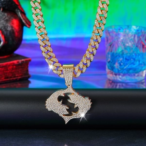 Close-up of golden iced-out Cuban link chain with a sparkling rhinestone pendant