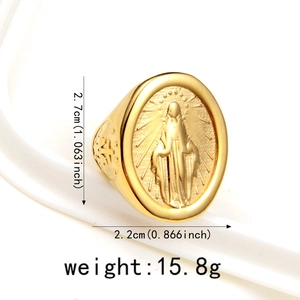 Gros plan sur une bague chevalière dorée ornée d'un relief religieux de la Vierge Marie