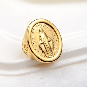 Bague dorée ovale avec relief Vierge Marie sur un support de présentation blanc