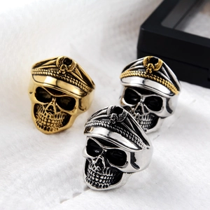 Detailed close-up of skull rings with military caps and eagle emblems in three finishes