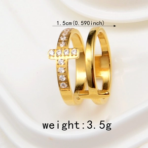 Détail d'une bague double dorée avec un charm de croix et de l'oxyde de zirconium blanc