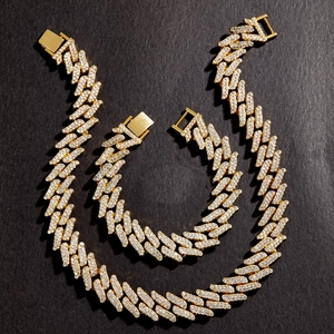 Herren Hip-Hop Gold-Cuban-Chain-Set mit eisigen Strass-Pfeilgliedern auf Stein-Hintergrund