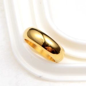 Macro view of gold minimalist round smooth ring with polished surface and metallic luster