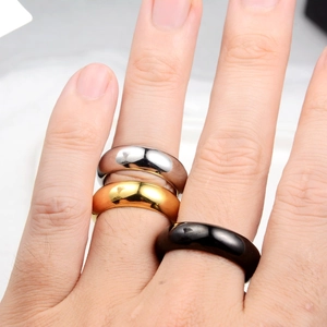 Close-up of hip-hop style wide polished rings in silver, gold, and black finishes