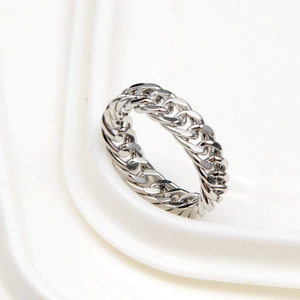 Polished silver cuban link chain ring for hip hop style on white ceramic display