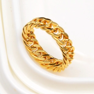 Polished golden Cuban link ring for hip hop style on a white textured background