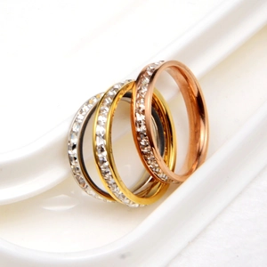 Dettaglio di tre anelli impilabili in argento, oro e oro rosa con cristalli pavé
