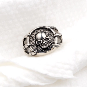 Retro hiphop silver skull ring with glasses held by dragon claws on white plush