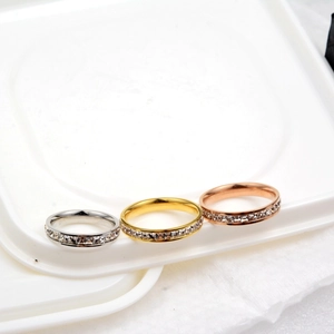 Dettaglio macro del set di tre anelli hip hop con pietre CZ scintillanti in oro e argento