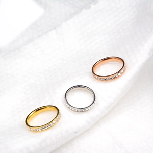 Dettaglio ravvicinato di un set di tre anelli con pavé di diamanti in oro, argento e oro rosa