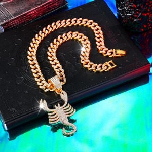 Detailed macro of gold hip hop Cuban chain with iced out scorpion zodiac pendant