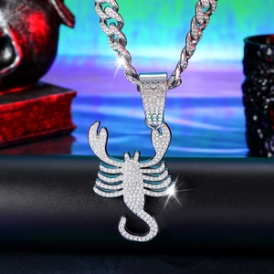 Macro view of iced-out silver Scorpio zodiac pendant with Cuban link chain and sparkling diamonds