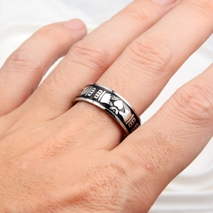 Détail de la bague Claddagh avec cœur en émail noir portée au doigt en gros plan