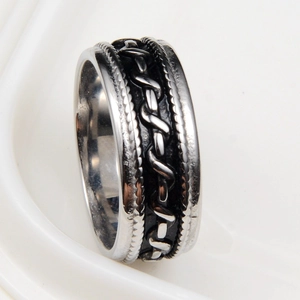 Vue macro d'une bague hip-hop vintage argentée avec texture tressée et bords perlés