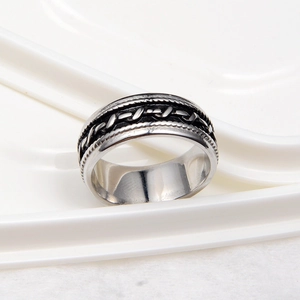 Détail macro d'une bague argentée avec texture de chaîne oxydée et anneau large