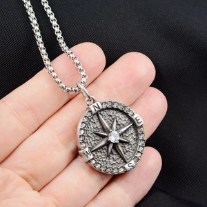 Macro shot of vintage compass pendant with sparkling crystals and engraved cardinal directions