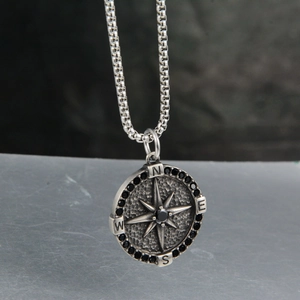 Close-up of vintage compass pendant with black zircon stones and steel square pearl chain