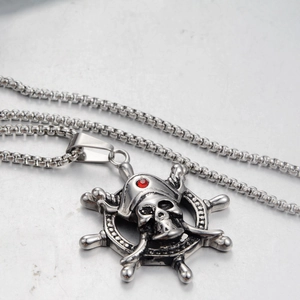Detailed macro view of pirate skull and ship wheel pendant with red gemstone