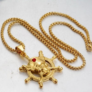 Close-up of golden pirate skull pendant with red gemstone on a vintage ship wheel
