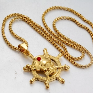 Close-up of golden pirate ship wheel pendant with skull and red gemstone detail
