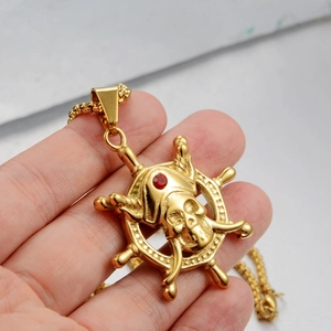 Golden pirate skull and helm necklace with a red gemstone pendant on a box chain