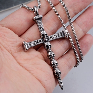 Vue macro du pendentif croix crâne punk avec gravure Deathly et chaîne en acier