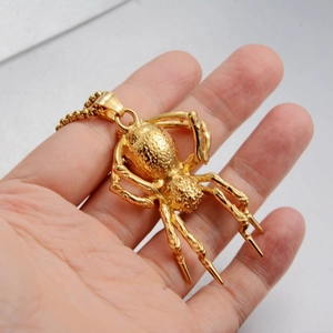 Detailed close-up of a 3D gold spider pendant with intricate textures and box chain