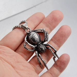 Detailed close-up of a stainless steel spider pendant with intricate punk textures