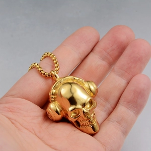 Detaillierte Ansicht des Totenkopf-Anhängers mit Kopfhörern in Gold-Optik an Kugelkette