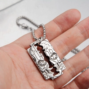 Macro shot of punk razor blade pendant with skull engraving and silver chain necklace