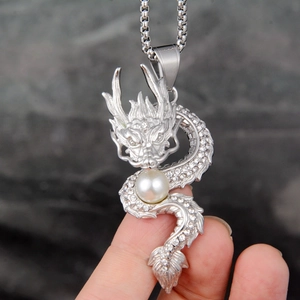 Vintage silver dragon necklace with rhinestone details and pearl bead on stone background