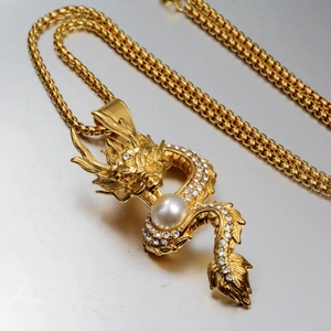 Chinese style gold dragon pendant necklace with white crystals and central pearl detail