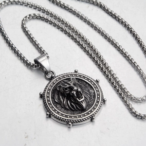 Macro detail of lion head embossed circular pendant on a rugged box chain necklace