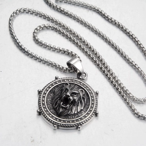 Detailed relief of a roaring lion head on a vintage silver round pendant with box chain