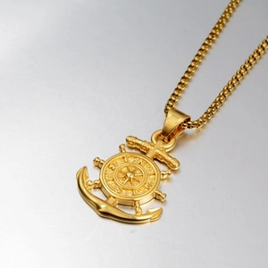 Detailed macro view of a gold nautical compass anchor pendant with elegant box chain