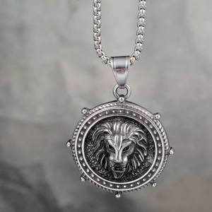 Close-up of a carved lion head relief pendant on a thick stainless steel chain